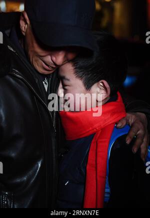 (180206) -- KANGLE, Feb. 6, 2018 -- Sun Jianjun cuddles with his father Sun Shihai, in Kangle County of northwest China s Gansu Province, Feb. 2, 2018. Spring Festival, or Chinese Lunar New Year, falls on Feb. 16 this year. Hundreds of millions of Chinese will return to their hometowns for family gatherings. 14-year-old Sun Jianjun and his 15 schoolmates are among these travellers eager back to home. On Feb. 1, the first day of the 2018 Spring Festival travel rush, they stepped onto a train in Nantong of east China s Jiangsu Province on a journey to home that is more than 2,000 kilometers away Stock Photo