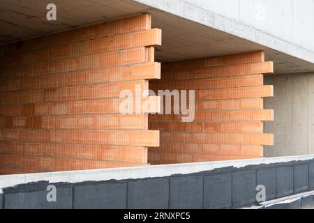 Red clay Ceramic Thermo Bricks construction material. Construction site with walls. Stock Photo