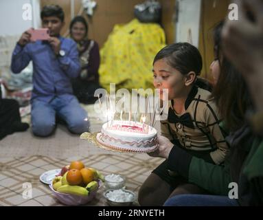 (180315) -- SARPOL-E ZAHAB, March 15, 2018 -- Paria (R) blows out the candles on her birthday cake at her conex home in Sarpol-e Zahab, western Iran, on March 10, 2018. Paria, 10-year-old Iranian-Kurdish girl, lost her father during a 7.3-magnitude earthquake on Nov. 12, 2017. Now, she is living with her mother and only brother in a conex home, as their house was completely destroyed during the tremor. She has had her father as the hero of her life, she sobbed. Asked what her top dream in her life is, she dropped her head saying in low voice: I cannot think of another disaster like this for an Stock Photo