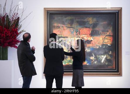 (180316) -- NEW YORK, March 16, 2018 -- A visitor (1st L) looks at the painting Tapovan by Indian contemporary artist Syed Haider Raza during the public viewing of Christie s Asian Art Week in New York, the United States, on March 16, 2018. Christie s on Friday kicked off its Asian Art Week, a series of auctions, viewings, and events, from March 16 to March 23. This season presents six distinct auctions including Fine Chinese Ceramics and Works of Art, South Asian Modern + Contemporary Art, etc. ) U.S.-NEW YORK-CHRISTIE S-ASIAN ART WEEK WangxYing PUBLICATIONxNOTxINxCHN Stock Photo