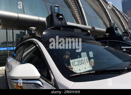 (180322) -- BEIJING, March 22, 2018 -- A staff member puts a temporary license plate in a vehicle for public road testing in Beijing, capital of China, March 22, 2018. Beijing released its first temporary license plates for Baidu s self-driving vehicles for public road testing on Thursday. The capital city has opened 33 roads with a total length of 105 kilometers for autonomous car testing outside the Fifth Ring Road and away from densely-populated areas on the outskirts. )(mcg) CHINA-BEIJING-SELF-DRIVING CAR-ROAD TESTING (CN) LuoxXiaoguang PUBLICATIONxNOTxINxCHN Stock Photo