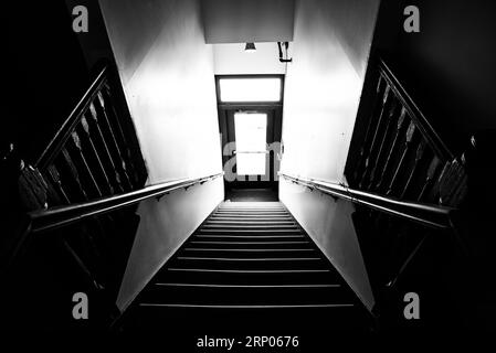 Eerie black and white photo of an interior staircase. Stock Photo