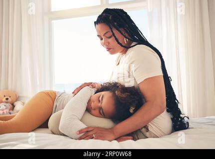 Family, mother and sad child for support lying on lap, relax and comfort in bedroom of house for depression. Love, woman and girl show care together Stock Photo