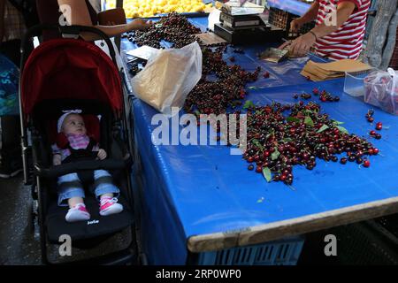 (180527) -- ATHENS, May 27, 2018 -- A baby looks at fresh cherries at a farmer s market in Athens, Greece, on May 26, 2018.) (dtf) GREECE-ATHENS-FARMER MARKET-ECONOMY MariosxLolos PUBLICATIONxNOTxINxCHN Stock Photo