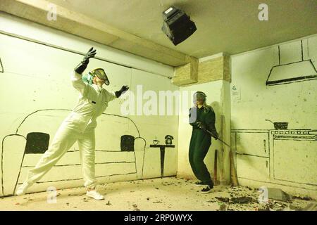 (180527) -- ATHENS, May 27, 2018 -- Two raging customers smash objects with a bat in one of the two specially arranged rooms at the first Rage Room in Athens, Greece, May 25, 2018. An anger room in Athens designed for stressed-out people to relieve their tension by smashing televisions, keyboards, plates and other objects is now open to public. )(srb) GREECE-ATHENS-RAGE ROOM ChrisxKissadjekian PUBLICATIONxNOTxINxCHN Stock Photo