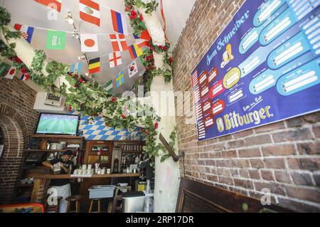 (180614) -- NEW YORK, June 14, 2018 -- A waiter prepares food for soccer fans at a bar in lower Manhattan of New York, the United States, June 14, 2018. As the 2018 FIFA World Cup kicked off in Russia on Thursday, some bars and restaurants in New York seized the opportunity to bring more business by providing live broadcast of matches and prolonging their business hours during the daytime. ) U.S.-NEW YORK-2018 WORLD CUP-COMMERCE WangxYing PUBLICATIONxNOTxINxCHN Stock Photo
