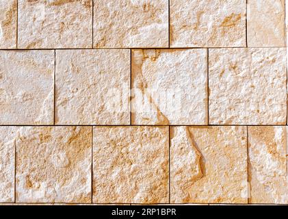 Natural background made from sand-colored stone wall with a square pattern. Stock Photo