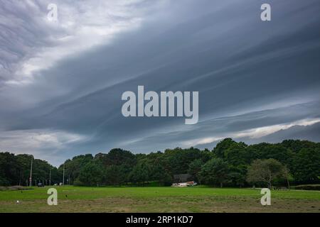Emerging severe weather is preceded by a shelf cloud (arcus) with striations Stock Photo