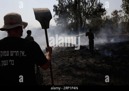 (180718) -- NAHAL OZ, July 18, 2018 -- Israeli firefighters attempt to extinguish a fire in a forest field near the Kibbutz of Nahal Oz, near the barrier between Israel and the Gaza Strip, on July 17, 2018. The fire was caused by inflammable material attached to a balloon flown by Palestinian protesters from inside Gaza Strip. ) (qxy) MIDEAST-NAHAL OZ-FIRE GilxCohenxMagen PUBLICATIONxNOTxINxCHN Stock Photo