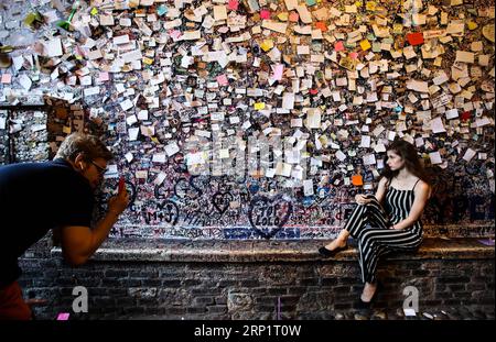 (180722) -- VERONA, July 22, 2018 -- A woman poses for photos with the graffiti wall of Juliet s House in Verona, Italy, July 20, 2018. Juliet s House, considered as the home of Juliet, heroine of Shakespeare s famous play Romeo and Juliet , is one of the well-known tourist spots in Verona. Verona is located in north Italy s Veneto. As one of the main tourist destinations in north Italy, the city has artistic heritages, annual fairs, shows, and operas. It was listed as a UNESCO world heritage site in 2000 for its historical buildings. ) (ly) ITALY-VERONA-TOURISM JinxYu PUBLICATIONxNOTxINxCHN Stock Photo