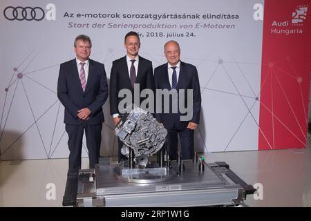 (180725) -- GYOR, July 25, 2018 -- Achim Heinfling (L), Chairman of the Audi Hungaria board of management, Hungary s Minister of Foreign Affairs and Trade Peter Szijjarto (C) and Audi board of management member for production and logistics Peter Kossler pose during the lauching ceremony at an Audi factory in Gyor, northwestern Hungary on July 24, 2018. German carmaker Audi launched the serial production of electric engines at its construction plant in Gyor on Tuesday, Hungarian news agency MTI reported. ) (djj) HUNGARY-GYOR-AUDI-ELECTRIC ENGINES-SERIAL PRODUCTION AttilaxVolgyi PUBLICATIONxNOTx Stock Photo