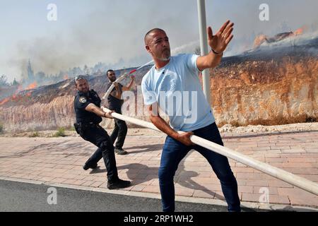 (180726) -- MODI IN, July 26, 2018 -- People try to put out a fire near Modi in, Israel, on July 25, 2018. Israel is in the throes of a heat wave that has seen temperatures soaring to 40 degrees Celsius and more on Wednesday. Firefighters have been working since the morning to extinguish more than 20 brush fires all over the country. ) (qxy) ISRAEL-MODI IN-FIRE GilxCohenxMagen PUBLICATIONxNOTxINxCHN Stock Photo