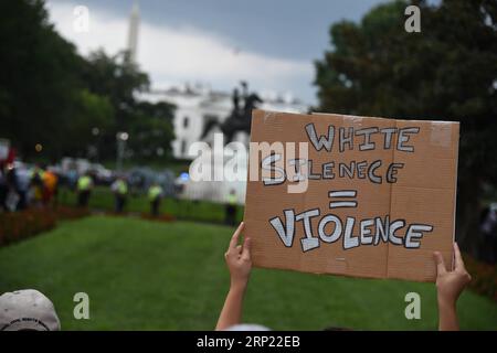 (180812) -- WASHINGTON, Aug. 12, 2018 -- An anti-protester holds a placard in front of the white supremacist-led rally near the White House, in Washington D.C., the United States, on Aug. 12, 2018. Thousands of anti-protesters gathered in several locations in central Washington Sunday afternoon, hours before a controversial right supremacist rally is scheduled. The protesters gathered in the country s capital to mark the one-year anniversary of the deadly Charlottesville protest, during which a white supremacist killed a female anti-protester, sparking nationwide furor. ) U.S.-WASHINGTON D.C.- Stock Photo