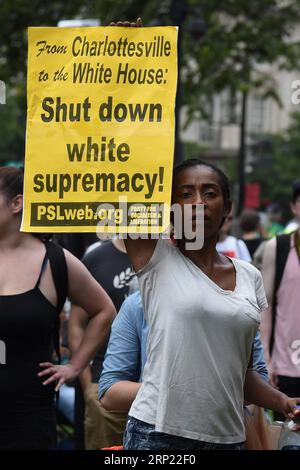 (180812) -- WASHINGTON, Aug. 12, 2018 -- An anti-protester holds a placard in front of the white supremacist-led rally near the White House, in Washington D.C., the United States, on Aug. 12, 2018. Thousands of anti-protesters gathered in several locations in central Washington Sunday afternoon, hours before a controversial right supremacist rally is scheduled. The protesters gathered in the country s capital to mark the one-year anniversary of the deadly Charlottesville protest, during which a white supremacist killed a female anti-protester, sparking nationwide furor. ) U.S.-WASHINGTON D.C.- Stock Photo