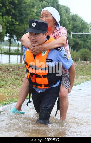 (180820) -- HUAIBEI, Aug. 20, 2018 (Xinhua) -- A rescuer transfers an old woman in flood in Huaibei City, east China s Anhui Province, Aug. 19, 2018. Typhoon Rumbia has brought heavy rain to Huaibei and some places in Huaibei were inundated by flood. (Xinhua/Wan Shanchao)(yxb) CHINA-ANHUI-TYPHOON RUMBIA-FLOOD(CN) PUBLICATIONxNOTxINxCHN Stock Photo