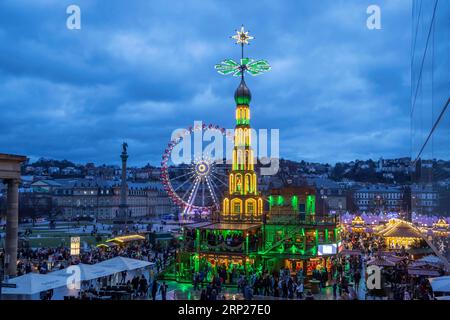 Christmas market Stuttgart, Christmas pyramid from the Erzgebirge at the Schlossplatz in the evening, in the background the Ferris wheel and the Stock Photo