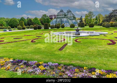 Schoenbrunn Palace Park with fountain, flower meadow and palm house, Vienna, Austria Stock Photo