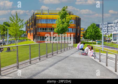 Students sitting in front of modern buildings on the campus of the University of Economics WU, modern architecture, Leopoldstadt, Vienna, Austria Stock Photo