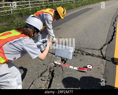 (180906) -- HOKKAIDO, Sept. 6, 2018 -- Rescuers check a damaged road after an earthquake in the town of Atsuma, Hokkaido prefecture, Japan, on Sept. 6, 2018. Nine people were confirmed dead and 300 people were injured after a strong earthquake rocking Japan s northernmost prefecture of Hokkaido early Thursday, local police and rescue officials said. ) (yg) JAPAN-HOKKAIDO-EARTHQUAKE DengxMin PUBLICATIONxNOTxINxCHN Stock Photo