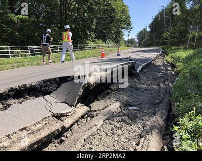 (180906) -- HOKKAIDO, Sept. 6, 2018 -- Rescuers walk along a damaged road after an earthquake in the town of Atsuma, Hokkaido prefecture, Japan, on Sept. 6, 2018. Nine people were confirmed dead and 300 people were injured after a strong earthquake rocking Japan s northernmost prefecture of Hokkaido early Thursday, local police and rescue officials said. ) (yg) JAPAN-HOKKAIDO-EARTHQUAKE DengxMin PUBLICATIONxNOTxINxCHN Stock Photo