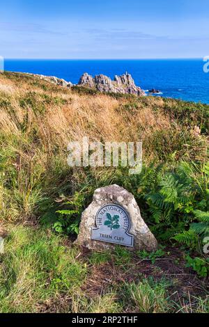 Waymarker with logo, National Trust, Treen cliffs, South West Coast Path, coastline at Treen, St Levan, Penwith, Cornwall, England, United Kingdom Stock Photo