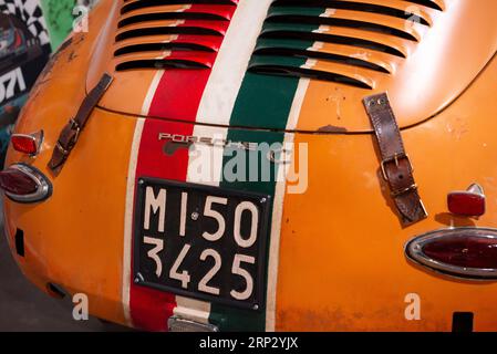 Rear view of orange Porsche 356 C 1600 racing car from 1964 with Italian number plate, Italian flag livery and leather hood or bonnet straps Stock Photo