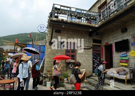 1(180917) -- PINGTAN, Sept. 17, 2018 -- Tourists visit the art zone of Rocks Can Sing in Beigang Village of Pingtan County, southeast China s Fujian Province, Sept. 7, 2018. When tourists get close to Rocks Can Sing, they may see artists playing music with the rocks, and people sipping coffee in rock houses. Rocks Can Sing is an art project which takes in accommodation, live music, restaurant, cafe and souvenir store. Now, a total of 10 young people from the mainland and Taiwan, including Taiwanese Lin I Chen and her boyfriend Liao Che Wei, work for the art project to promote cultural and tour Stock Photo