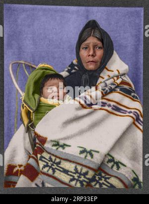 Yakima squaw and papoose. Photograph shows a Yakima Indian woman, half-length portrait, seated, facing front, wrapped in blanket, holding a baby in a Stock Photo