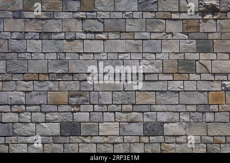 Stone wall / brick wall - evenly spaced grey blocks. Stock Photo