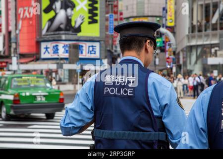 Tokyo, Japan - 21 June 2023: Japanese police presence at Shibuya Crossing, known as the scramble, the busiest pedestrian crossing in the world. Stock Photo