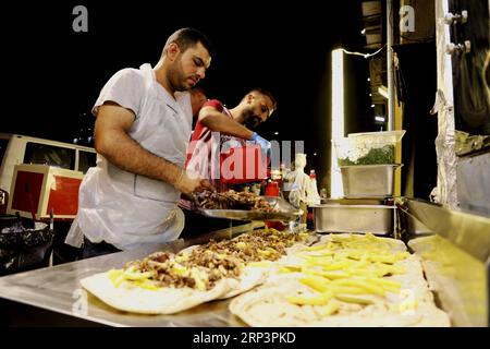 (181013) -- BAGHDAD, Oct. 13, 2018 -- Street vendors sell food in Al-Mansour district, Baghdad, Iraq, Oct. 13, 2018. Nightlife has thrived in some districts of Baghdad with the significant improvement of security situation after Iraqi security forces fully defeated the extremist Islamic State militants across the country late in 2017. ) IRAQ-BAGHDAD-NIGHTLIFE KhalilxDawood PUBLICATIONxNOTxINxCHN Stock Photo