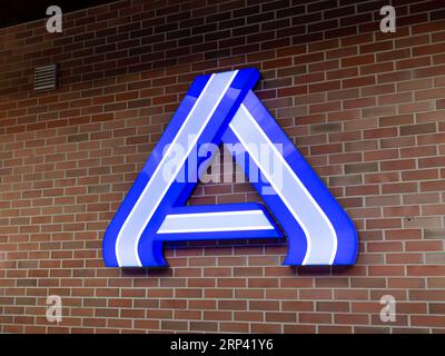 Aldi Nord logo sign on a brick wall of a supermarket. The big letter A is illuminated in a blue color. The grocery store offers cheap food and drinks. Stock Photo