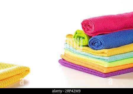 Stack of kitchen microfiber towels in bright colors on a white background.Close up,Rolled up napkins on top Stock Photo