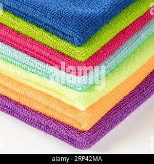 Stack of kitchen microfiber towels in bright colors on a white background.Close up.Photo taken from the corner of a stack of napkins Stock Photo