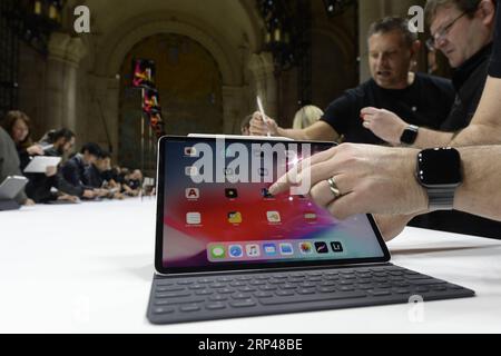 (181030) -- NEW YORK, Oct. 30, 2018 () -- People look at an Apple iPad Pro during an event to unveil new Apple products in Brooklyn, New York, the United States, on Oct. 30, 2018. Apple Inc. on Tuesday launched its new iPad Pro, MacBook Air and Mac mini at an event in Brooklyn, New York City, offering long-awaited updates to some of its popular devices. () U.S.-NEW YORK-APPLE-NEW PRODUCTS-UNVEILING Xinhua PUBLICATIONxNOTxINxCHN Stock Photo