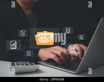 Businessmen use computers to manage documents and important information, folder document Management System DMS Open File folder with flying blank docu Stock Photo