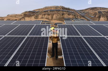 (181107) -- SUIDE, Nov. 7, 2018 -- A worker checks solar panels at a photovoltaic power station built under an inter-village poverty relief program in Huojiaping Village of Yihe Township, Suide County, northwest China s Shaanxi Province, Nov. 7, 2018. Located on the Loess Plateau, Suide County has abundant sunshine and idle lands which are ideal for the construction of photovoltaic power stations. Currently, local authorities are working with a provincial branch of electricity service provider State Grid on a 33-megawatt photovoltaic power station. ) (lmm) CHINA-SHAANXI-RURAL ECONOMY-SOLAR POW Stock Photo