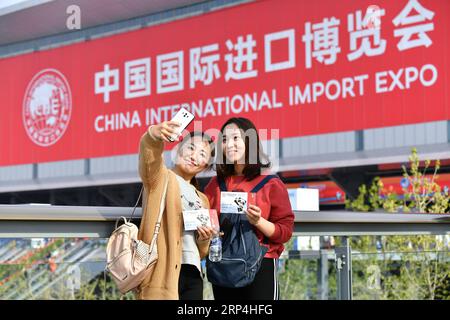 (181109) -- SHANGHAI, Nov. 9, 2018 -- Visitors Chen Fei (L) and Weng Jingyi pose for photos in front of the venue of the first China International Import Expo (CIIE) in Shanghai, east China, Nov. 9, 2018. The CIIE is opened to group visitors from Nov. 9 to Nov. 10. ) (IMPORT EXPO)CHINA-SHANGHAI-CIIE-GROUP VISITORS (CN) LixXin PUBLICATIONxNOTxINxCHN Stock Photo