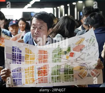 (181110) -- SHANGHAI, Nov. 10, 2018 -- A visitor checks a map during the first China International Import Expo(CIIE) in Shanghai, east China, Nov. 10. 2018. The CIIE concluded here on Saturday. )(wsw) (IMPORT EXPO)CHINA-SHANGHAI-CIIE-CONCLUSION (CN) ShenxBohan PUBLICATIONxNOTxINxCHN Stock Photo