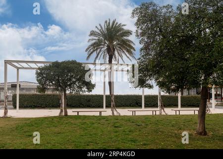 Glimpse of the seafront garden with trees, pergola and benches, empty in winter, Savona, Liguria, Italy Stock Photo