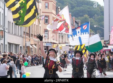 Aue Bad Schlema, Germany. 03rd Sep, 2023. Flag-wavers stride through the city center during the Saxon Day parade. Saxony's largest folk and local festival traditionally takes place on the first weekend in September. Credit: Sebastian Willnow/dpa/Alamy Live News Stock Photo