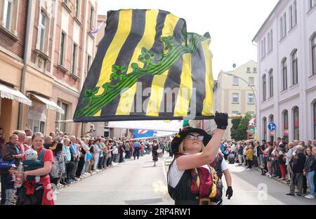 Aue Bad Schlema, Germany. 03rd Sep, 2023. Flag-wavers stride through the city center during the Saxon Day parade. Saxony's largest folk and local festival traditionally takes place on the first weekend in September. Credit: Sebastian Willnow/dpa/Alamy Live News Stock Photo