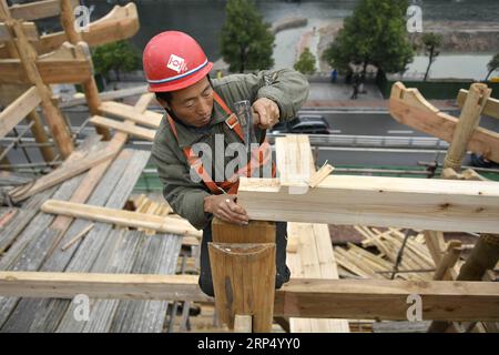 (181121) -- ENSHI, Nov. 21, 2018 -- A carpenter builds stilt houses with traditional skills by the Gongshui River in the center of Xuan en County, central China s Hubei Province, Nov. 21, 2018. A total of five stilt houses were built in the county to display local culture of Tujia ethnic group for tourists. The construction technique of stilt houses of the Tujia ethnic group was listed as the national intangible cultural heritage in 2011. ) (ry) CHINA-HUBEI-XUAN EN-STILT HOUSE (CN) SongxWen PUBLICATIONxNOTxINxCHN Stock Photo