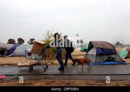(181122) -- BUTTE, Nov. 22, 2018 (Xinhua) -- Residents walk near the tents at a parking lot in Chico of Butte County, California, the United States, Nov. 21, 2018. Local officials warned that the rain after the wildfire could cause risk of flash floods and mudflows. (Xinhua/Wu Xiaoling)(clq) U.S.-CALIFORNIA-BUTTE-WILDFIRE-RAIN PUBLICATIONxNOTxINxCHN Stock Photo