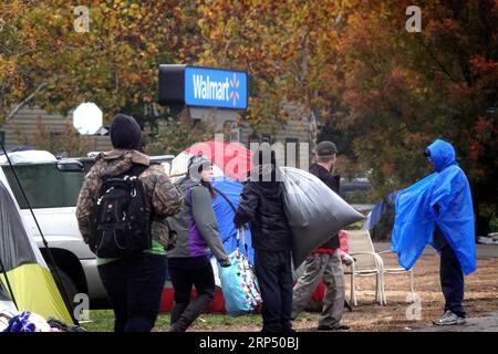 (181122) -- BUTTE, Nov. 22, 2018 (Xinhua) -- Residents move to a tent in rain at a parking lot in Chico of Butte County, California, the United States, Nov. 21, 2018. Local officials warned that the rain after the wildfire could cause risk of flash floods and mudflows. (Xinhua/Wu Xiaoling)(clq) U.S.-CALIFORNIA-BUTTE-WILDFIRE-RAIN PUBLICATIONxNOTxINxCHN Stock Photo