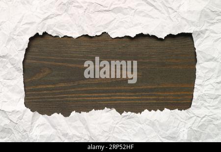 Ripped White Paper Frame with Dark Brown Wooden Copy Space Stock Photo
