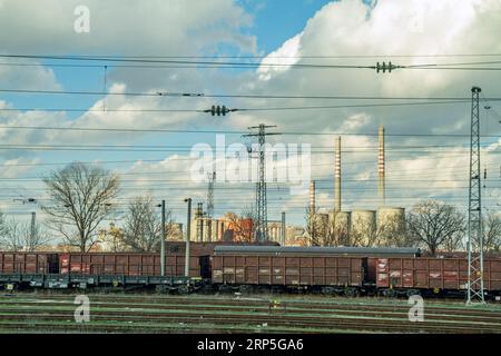 A train station with old freight cars next to a thermal power plant in Bulgaria Stock Photo