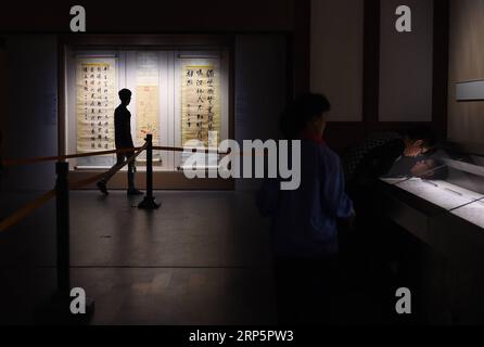 (181221) -- BEIJING, Dec. 21, 2018 (Xinhua) -- File photo taken on Sept. 8, 2015 shows visitors viewing an exhibition at the Palace Museum in Beijing, capital of China. The Palace Museum, also known as the Forbidden City, has taken new approaches, such as TV show, music and games, to promote its cultural relics and Chinese traditional culture. It reaches out to the public with new digital technology by integrating modern technology with its history and splendid traditional culture spanning 600 years. Visitors may walk directly into the emperor s residence and, through VR, see everything as it Stock Photo