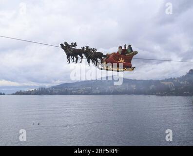 (181222) -- MONTREUX (SWITZERLAND), Dec. 22, 2018 -- A Santa Claus waves to the crowd from his flying sleigh drawn by reindeers over Lake Leman at sunset in Montreux, Switzerland, on Dec. 22, 2018. The flying Santa Claus stunt show is part of promotional activities by the Christmas market in Montreux, which is one of the most famous and biggest markets of its kind in Switzerland. ) SWITZERLAND-MONTREUX-SANTA CLAUS-FLYING SLEIGH XuxJinquan PUBLICATIONxNOTxINxCHN Stock Photo