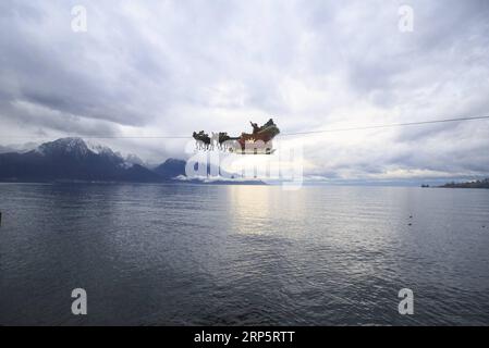 (181222) -- MONTREUX (SWITZERLAND), Dec. 22, 2018 -- A Santa Claus waves to the crowd from his flying sleigh drawn by reindeers over Lake Leman at sunset in Montreux, Switzerland, on Dec. 22, 2018. The flying Santa Claus stunt show is part of promotional activities by the Christmas market in Montreux, which is one of the most famous and biggest markets of its kind in Switzerland. ) SWITZERLAND-MONTREUX-SANTA CLAUS-FLYING SLEIGH XuxJinquan PUBLICATIONxNOTxINxCHN Stock Photo